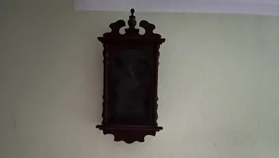 leerer Uhrenkasten ohne Uhr an einer gelben Wand